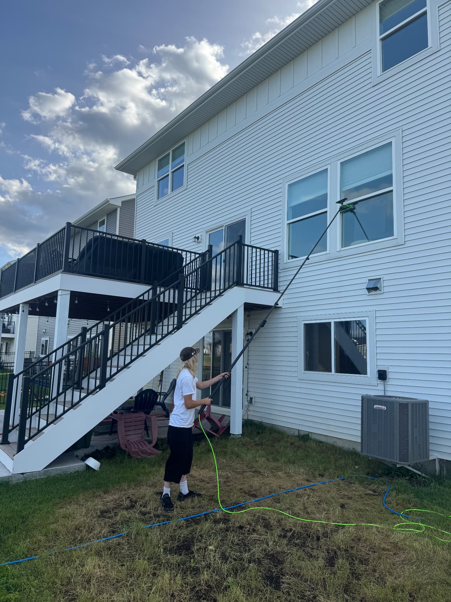 Prime Shine Cleaning technician cleaning upper-story residential windows